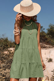 Matcha green halter neck tiered mini dress with a bow-back detail.