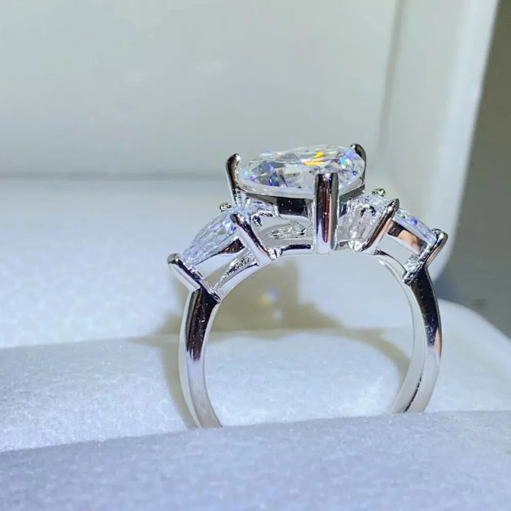 Silver ring with a large heart-cut diamond and two pear-cut side stones.