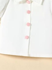 White baby top with puff sleeves and pink button details