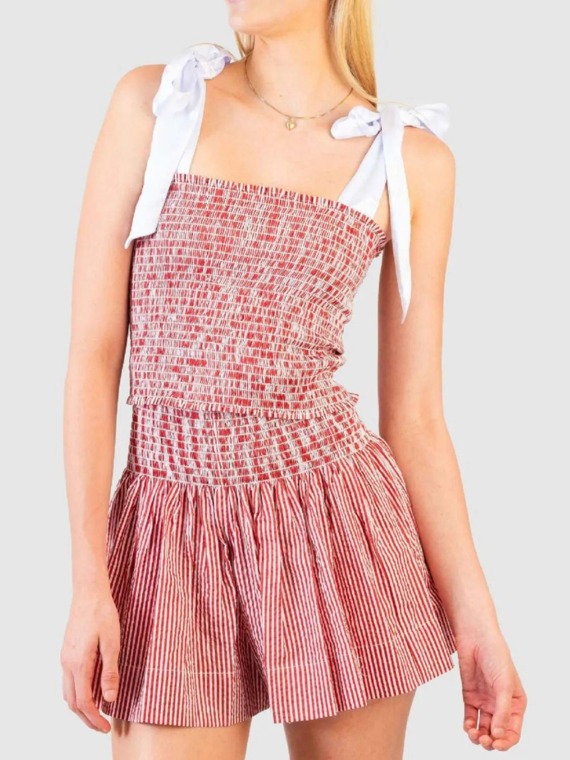 Smocked bodice and skirt set in strawberry seersucker with white tie straps.