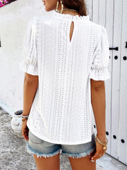 White eyelet blouse with ruffled mock neck and puff sleeves.