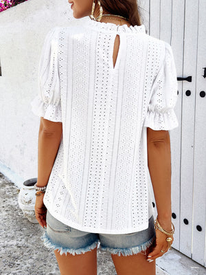White eyelet blouse with ruffled mock neck and puff sleeves.