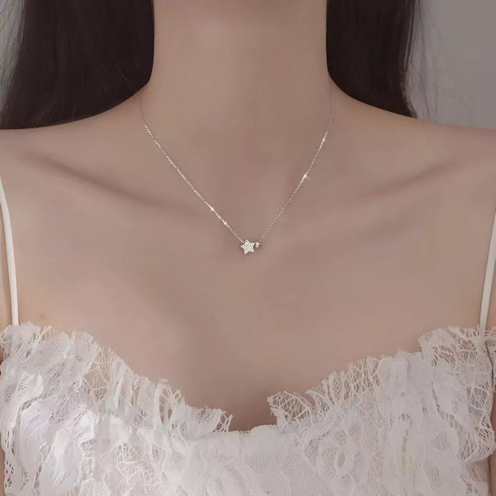 White gold necklace with a small, sparkling star pendant.