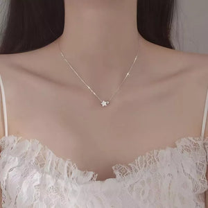 White gold necklace with a small, sparkling star pendant.
