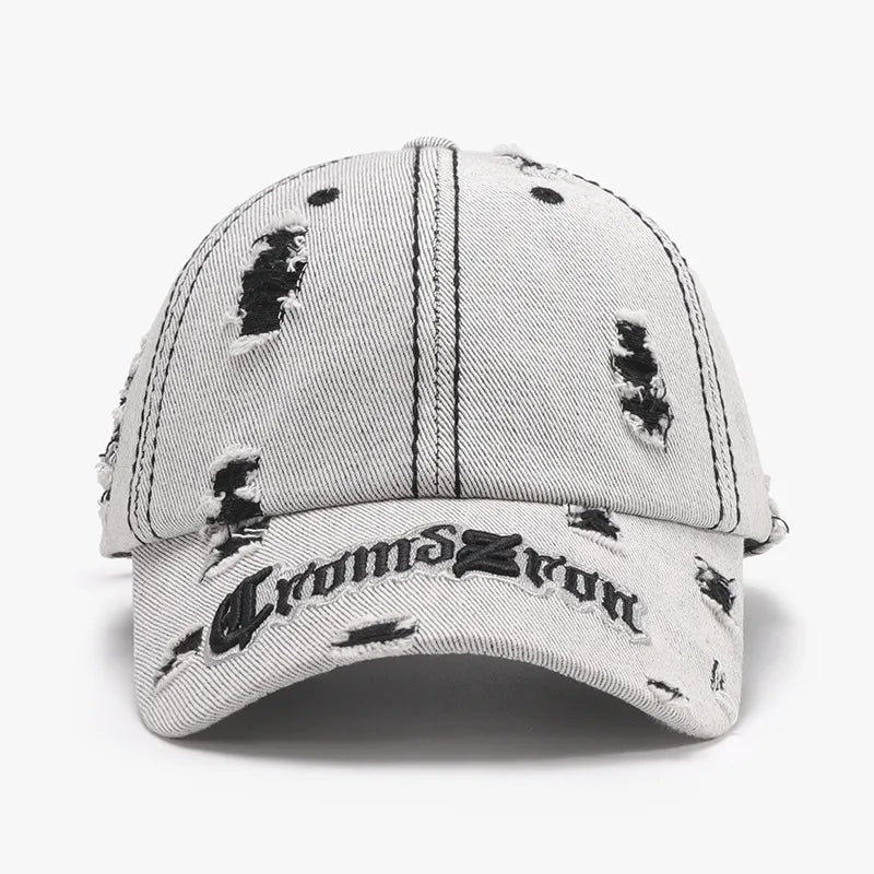 Distressed baseball cap in light gray denim with black embroidered text and rips.