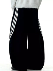 Men's black wide-leg sweatpants with white side stripes and a relaxed fit.