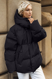 Black oversized puffer jacket with hood and quilted detail.