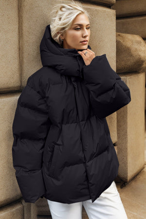 Black oversized puffer jacket with hood and quilted detail.