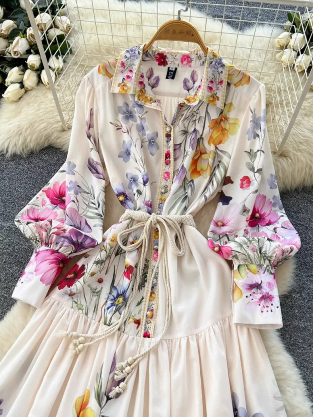 Vibrant floral midi dress with lantern sleeves, button front, and tie waist.