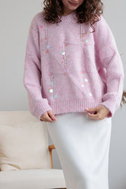 Blush pink diamond knit sweater with scattered iridescent sequins and openwork details.