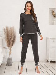 Charcoal loungewear set with white striped trim on cuffs, pocket, and hem.