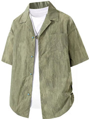 Relaxed fit military green camp collar shirt with button front and chest pocket, worn over a white tee.