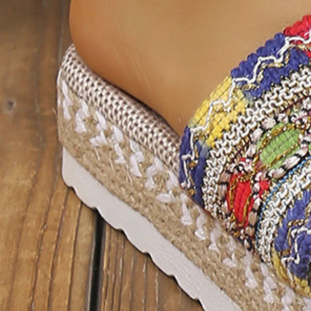 Embroidered espadrille platform slides with multicolor woven strap detail.