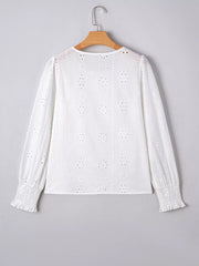 White cotton blouse with eyelet embroidery, ruffled cuffs, and smocked wrists.