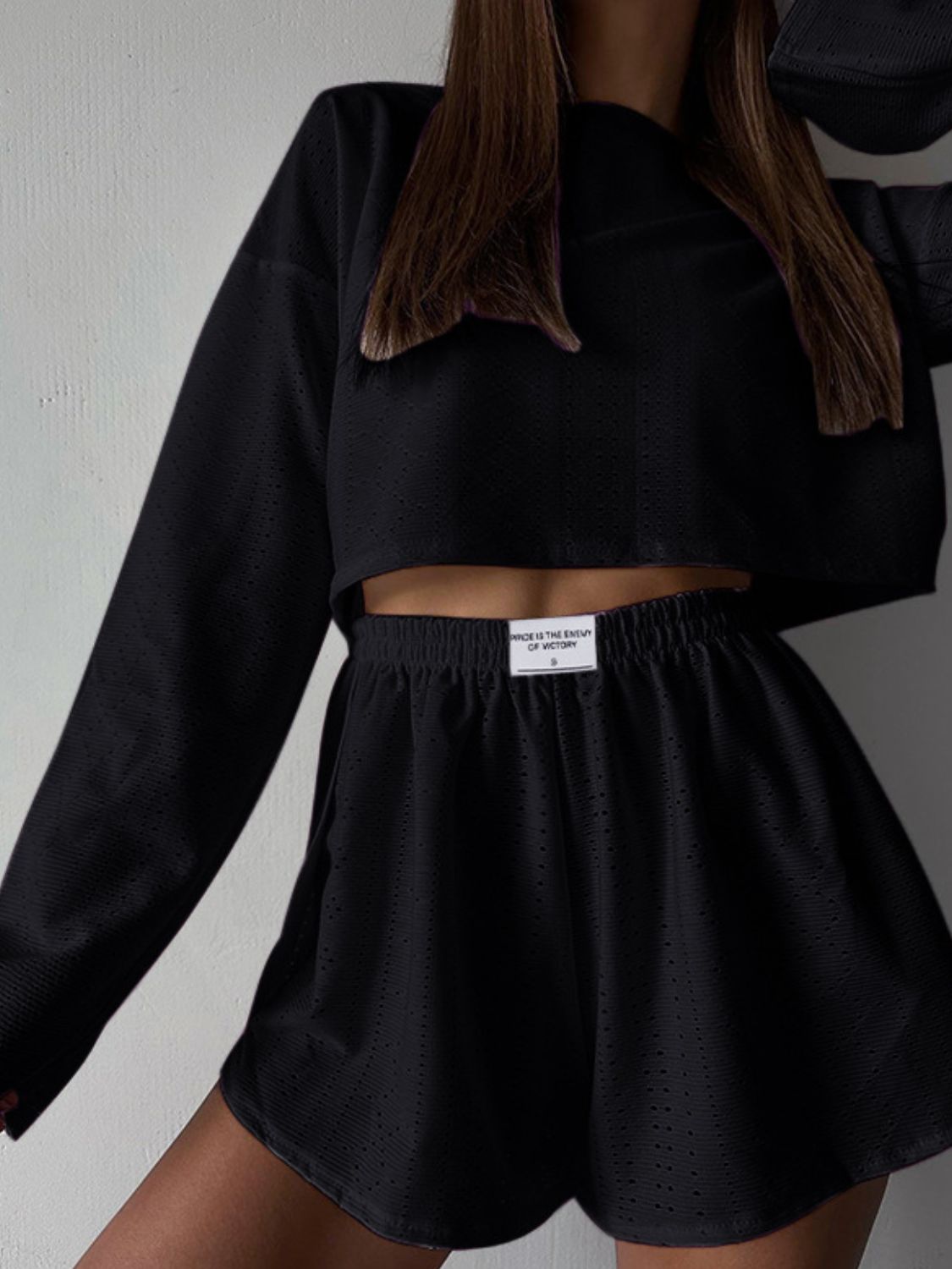 Black perforated crop top and shorts set with a drawstring waist.