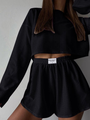 Black perforated crop top and shorts set with a drawstring waist.