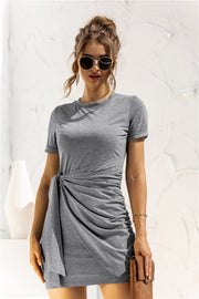 Mid gray jersey knot-front mini dress with short sleeves and a draped detail.