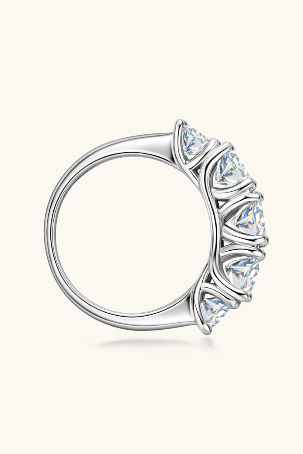 Silver five-stone moissanite eternity band ring with prong-set triangle-cut stones.