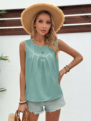 Sleeveless light blue top with V-neck pleats and textured fabric.