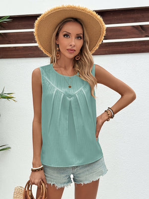 Sleeveless light blue top with V-neck pleats and textured fabric.