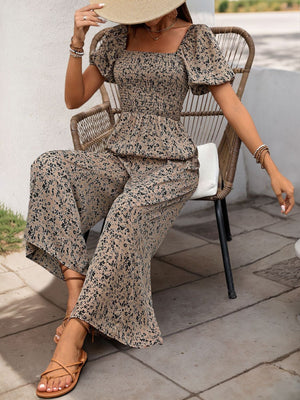 Taupe floral smocked bodice jumpsuit with puff sleeves and wide-leg palazzo pants.