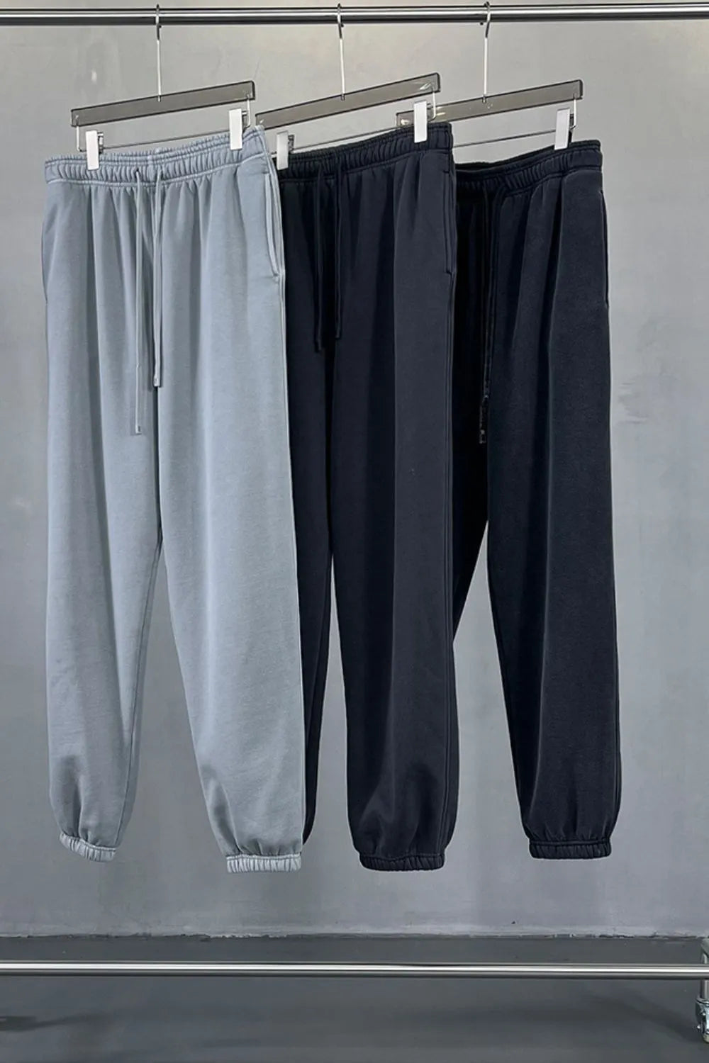 Relaxed fit sweatpants in gray and black with drawstring waist and cuffed ankles.