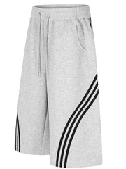 Gray wide-leg cropped sweatpants with black side stripes and drawstring waist.