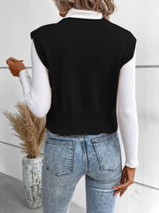 Black knit vest with ribbed trim and crew neck, worn over a white turtleneck.