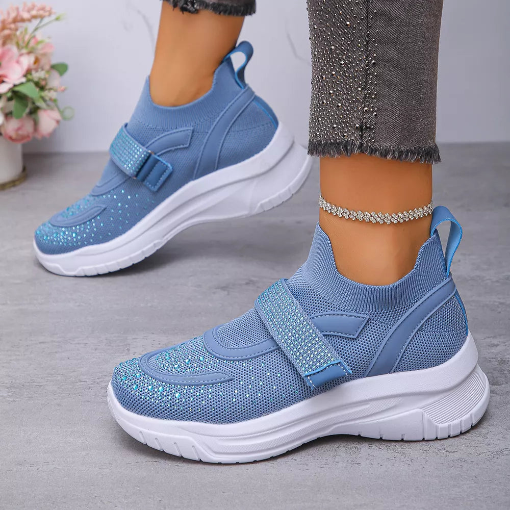 Blue slip-on mesh sneakers with adjustable strap and rhinestone details.