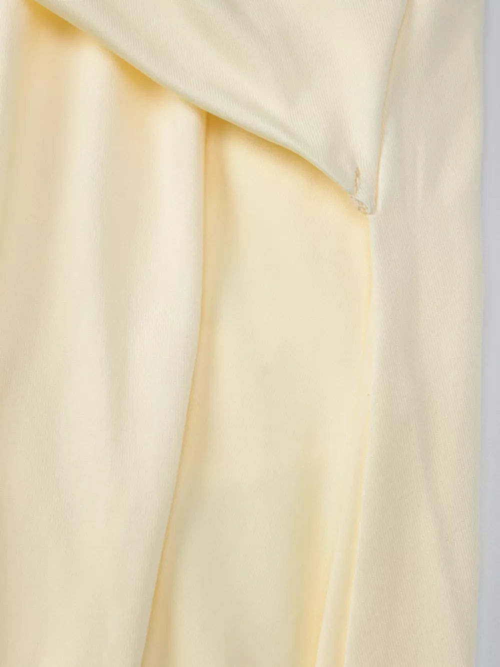 Yellow ruched halter neck maxi dress detail showing fabric texture and draping.