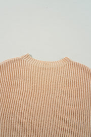 Tan ribbed knit pullover sweater with asymmetric hem detail.