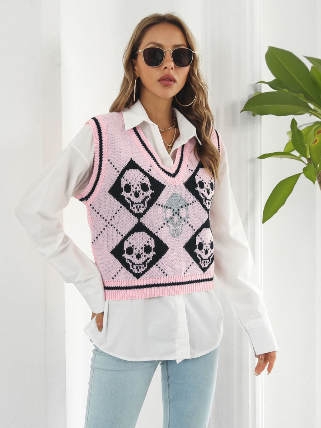 Pink argyle knit vest with skull motif and V-neck.