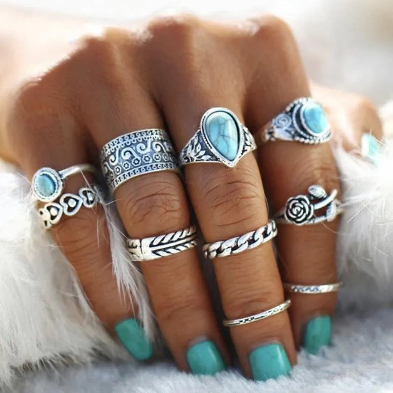Bohemian silver ring stack with turquoise stones, featuring ornate and chain designs.