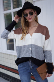 Colorblock acrylic cardigan with metallic trim, V-neck, button front, and striped pattern in brown, white, grey, and black.