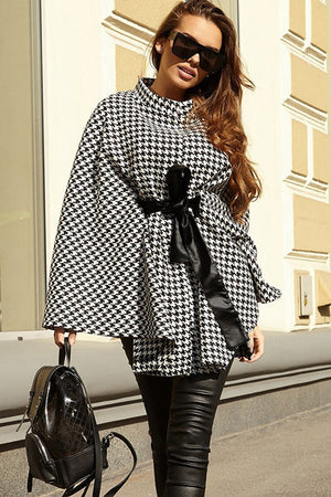 Houndstooth cape trench coat with black bow belt and high collar.
