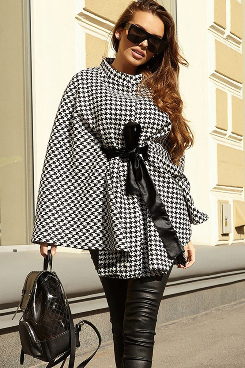 Houndstooth cape trench coat with black bow belt and high collar.