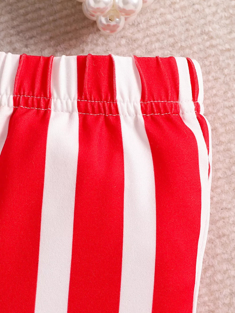 Patriotic toddler two-piece set with red and white stripes, cotton fabric, and elastic waistband.