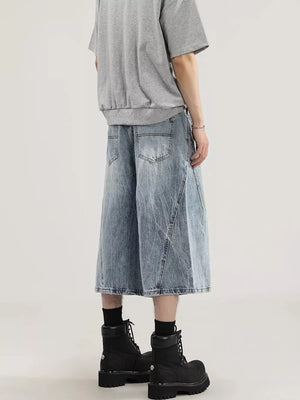 Men's light wash denim capris with a relaxed fit and wide leg, showing back pockets and distressed details.