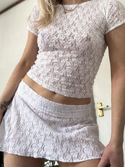 White floral lace cropped co-ord set with short sleeves and a mini skirt.