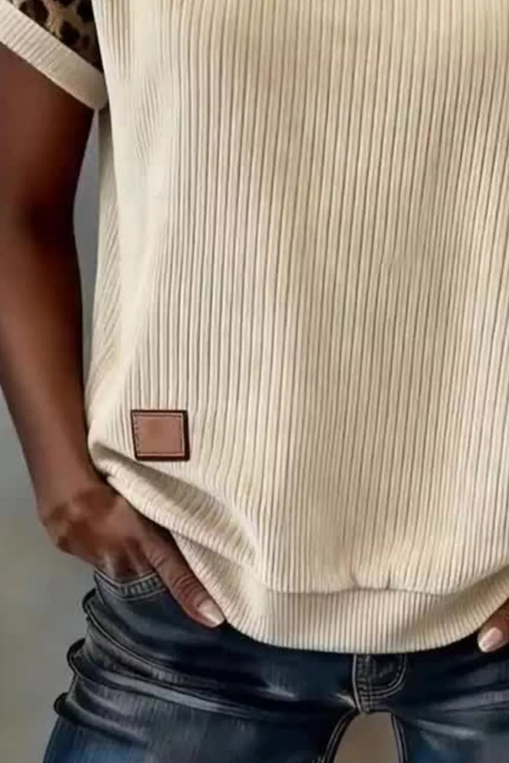 Beige ribbed crew neck t-shirt with leopard print sleeves and faux leather patch detail.