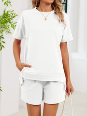 White relaxed two-piece set with crew neck tee and shorts, featuring pockets.