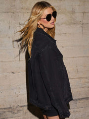Black denim trucker jacket with collar and button details, styled casually.