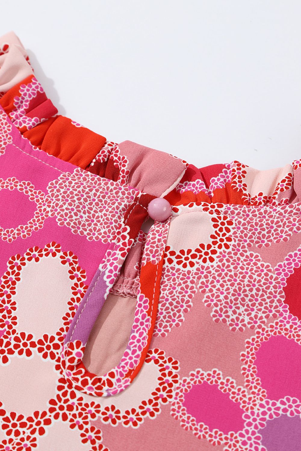 Floral embroidered yoke ruffle sleeve top in strawberry pink with a keyhole neckline and button closure.