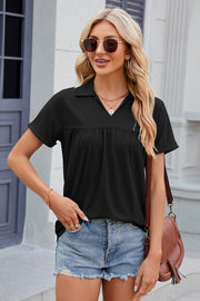 Black polo top with short sleeves and gathered yoke detail