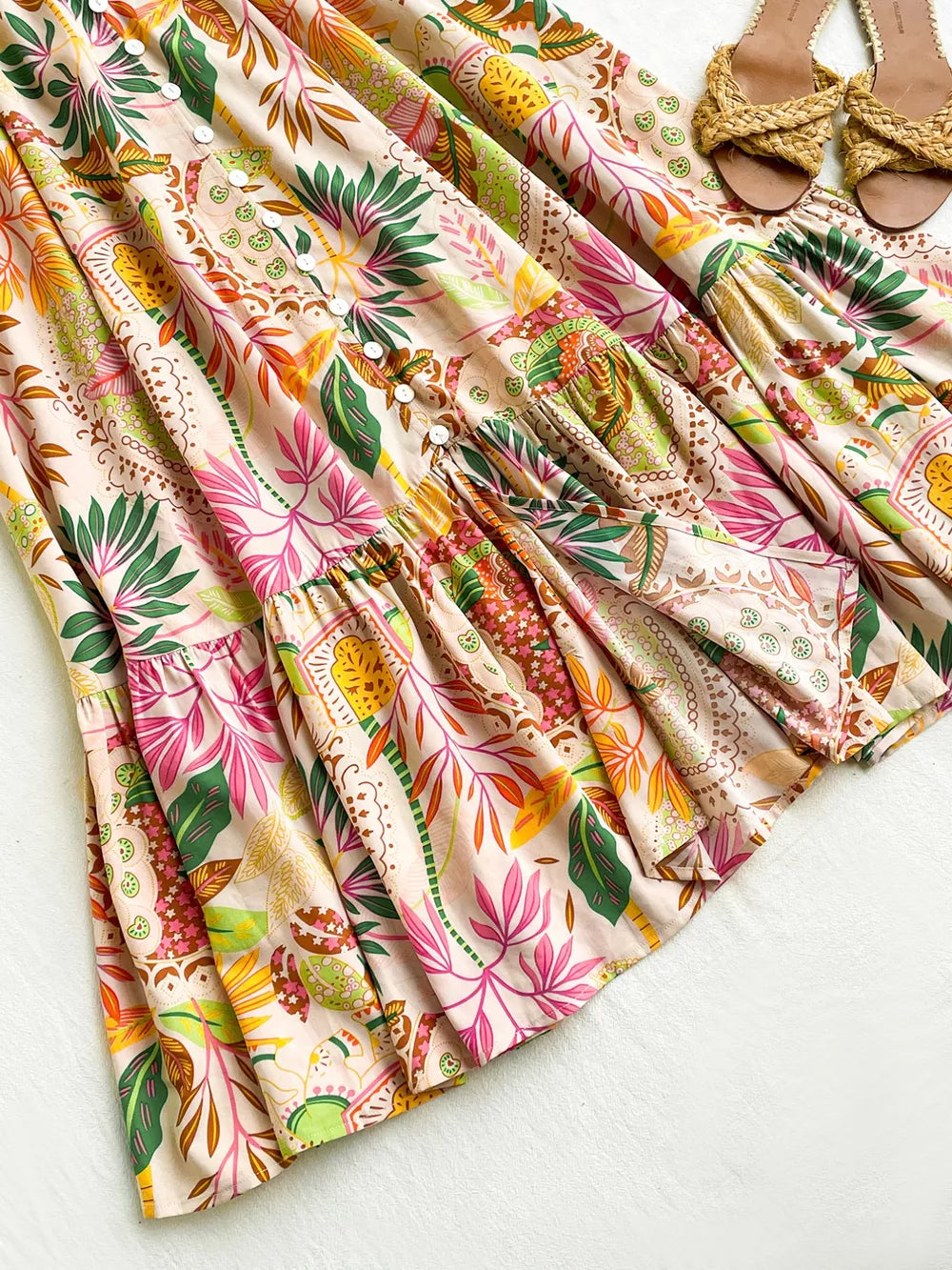 Tropical ruched maxi skirt with ruffles, decorative buttons, and a vibrant floral print.