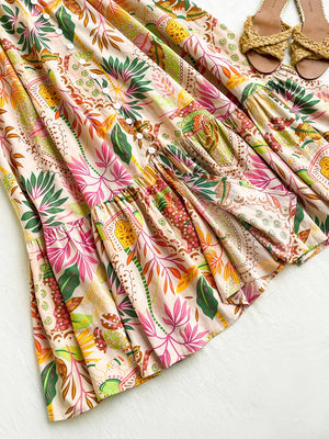 Tropical ruched maxi skirt with ruffles, decorative buttons, and a vibrant floral print.