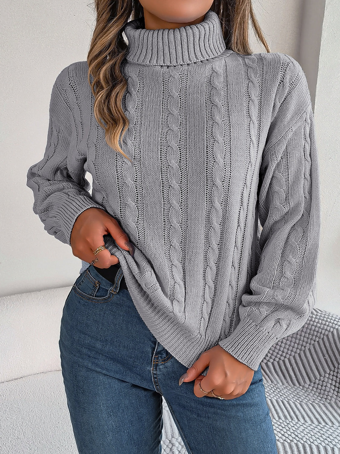 Dark Gray cable knit turtleneck sweater with voluminous sleeves and ribbed cuffs.