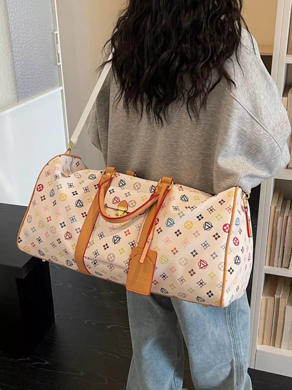 Vibrant monogram leather travel bag with adjustable strap and tan trim.