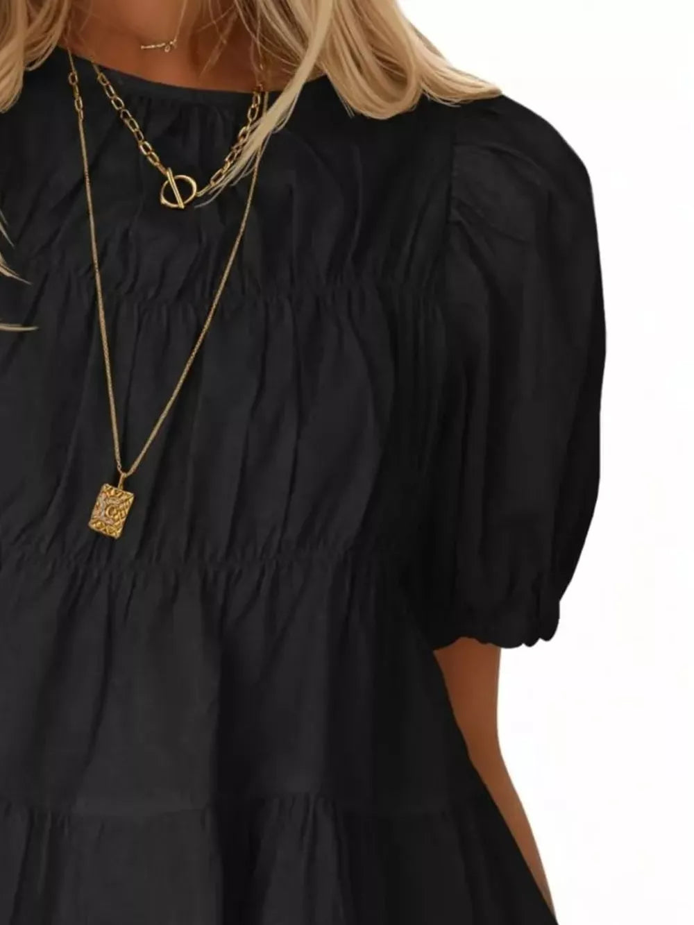 Black maternity blouse with puff sleeves, ruffled tiers, and shirred bodice detail.