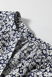 Blouse with navy and white floral print, featuring a notched neckline and gathered detail.